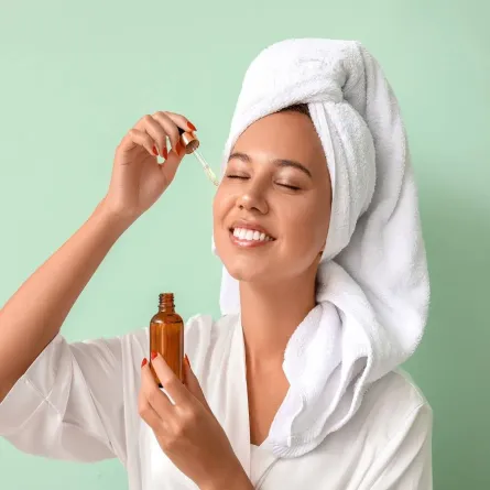 صورة لامرأة تضع زيتاً على وجهها 