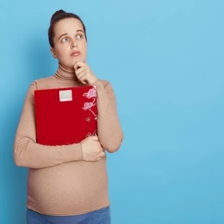 صورة لامرأة حامل تحمل ميزاناً