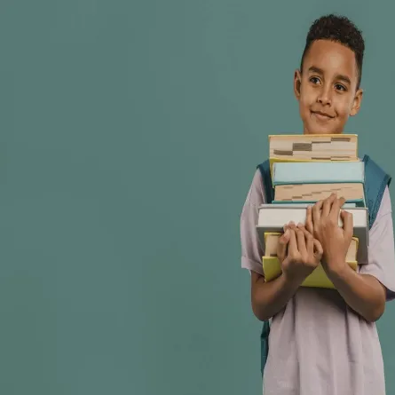 صورة لطفل يحمل كتب