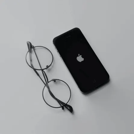 صورة نظارة ستيف جوبز بجوار هاتف آيفون