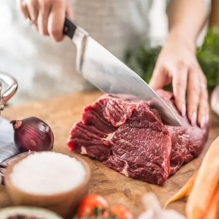 صورة لامرأة تقطع اللحم