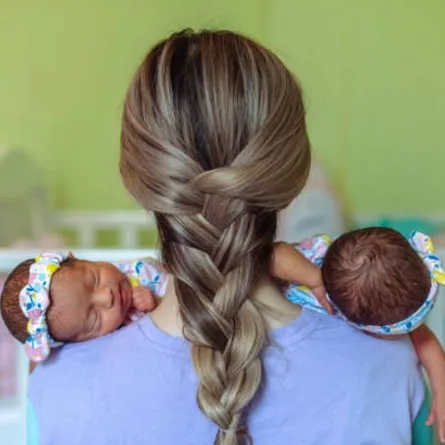 صورة لأم تعتني بتوأمها