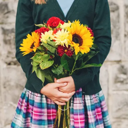 صورة لطالبة تمسك بورود الترحيب