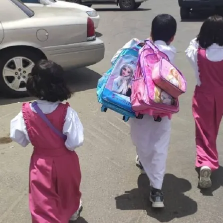 صورة الطفل مشعل يحمل حقيبة شقيقتيه