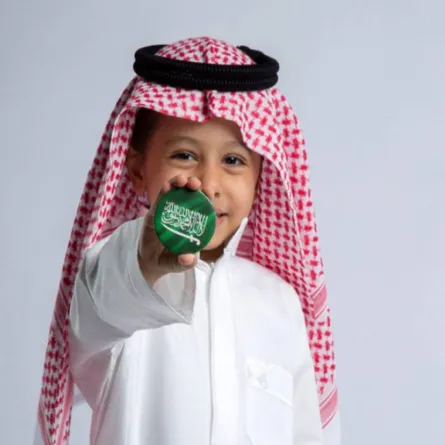 صورة لطفل يحمل علم السعودية