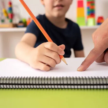 صورة لطفل يتعلم المبادئ الأساسية للكتابة