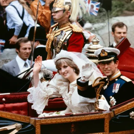 Lady Diana and Charles, Prince of Wales, acknowledge the crowd as they arrive in a carriage at Buckingham Palace on July 29, 1981, after their wedding in St Paul's Cathedral. POOL / AFP