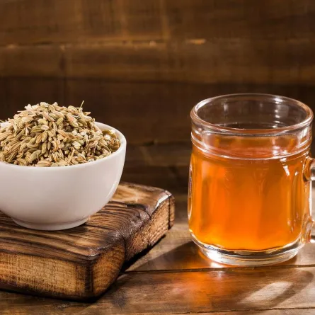 صورة لطبق يحتوي على بذور الشمر وكوب به ماء الشمر