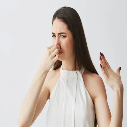 صورة لامرأة تغطي أنفها