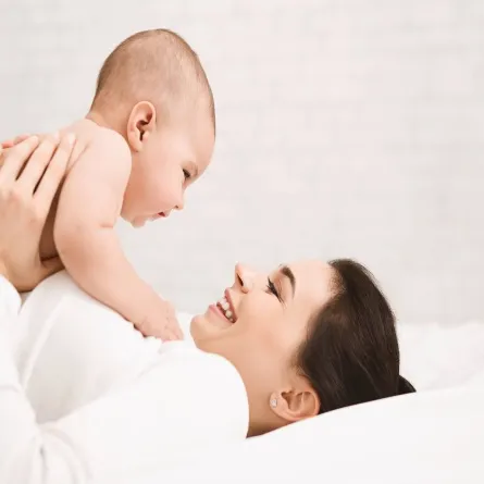 صورة لأم تلعب مع طفلها الرضبيع