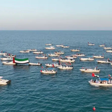 حملت قوارب الصيد والمحامل والسفن المشاركة في المسيرة علم الإمارات. الصورة من "وام"