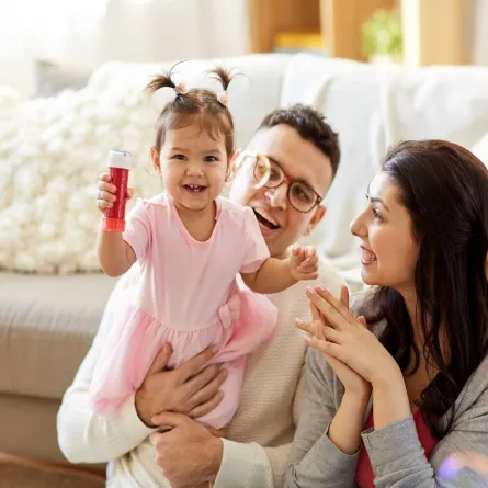 صورة لأب وأم يلعبان مع طفلتهما