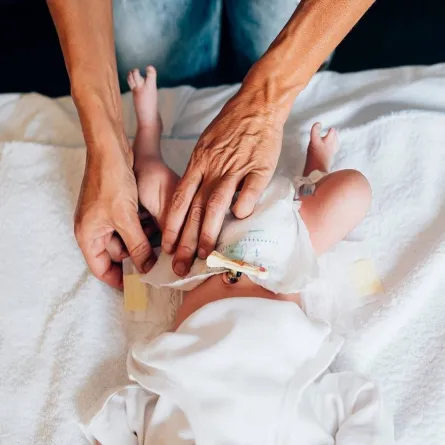 صورة لأم تغير حفاض طفلها