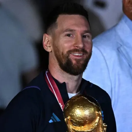 Argentina's captain and forward Lionel Messi (C) holds the FIFA World Cup Trophy upon arrival at Ezeiza International Airport after winning the Qatar 2022 World Cup tournament in Ezeiza, Buenos Aires province, Argentina on December 20, 2022. Luis ROBAYO / AFP
