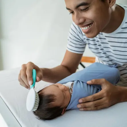 صورة لأب يمشط شعر طفله