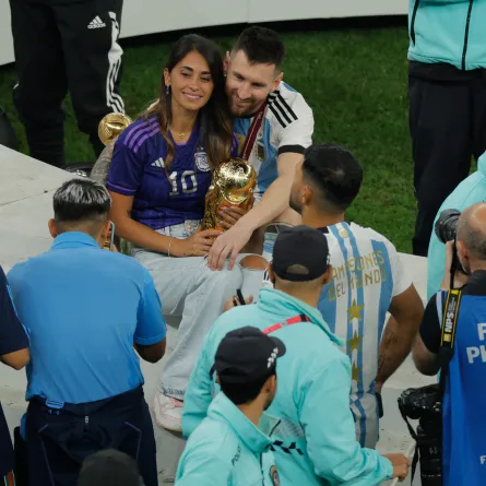  Lionel Messi and his wife Antonela Roccuzzo pose while holding the World Cup Trophy at the end of the Qatar 2022 World Cup final football match between Argentina and France at Lusail Stadium in Lusail, north of Doha on December 18, 2022. Odd ANDERSEN / AFP