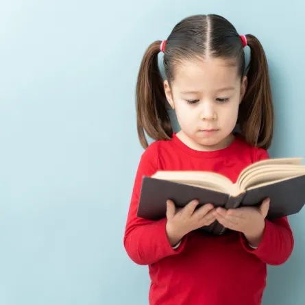 صورة لطفلة تقرأ كتاباً
