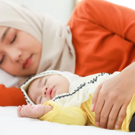 صورة لأم تنام بجوار طفلها