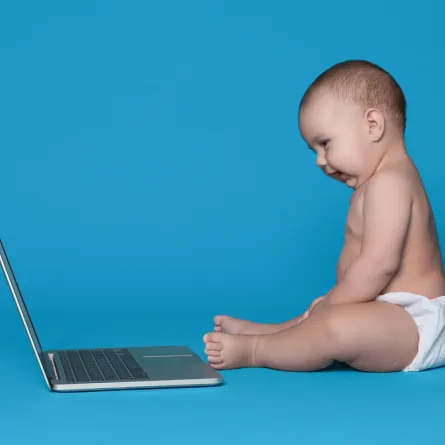 صورة لطفل يقلد حركات الجلوس وراء الكمبيوتر