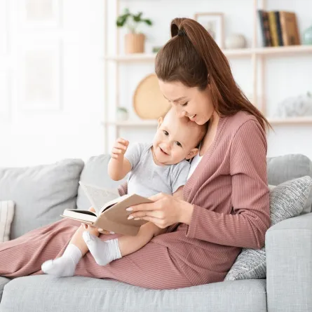 صورة لأم تقرأ لطفلها الرضيع