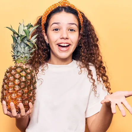 صورة لطفلة تحمل فاكهة