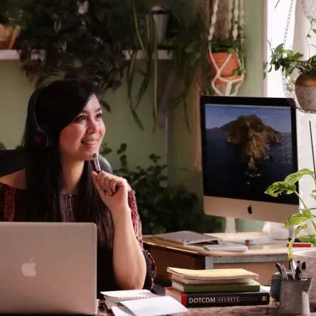 فتاة تجلس أمام الكمبيوتر المحمول