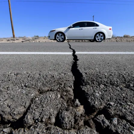 A car drives past a crack in the road on Highway 178, California, on July 4, 2019 FREDERIC J. BROWN / AFP