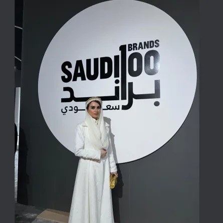 المصممة نبيلة ناظر ترتدي تصميمها الخاص المعروض ضمن معرض 100 براند سعودي في كأس السعودية-الصورة من المصدر