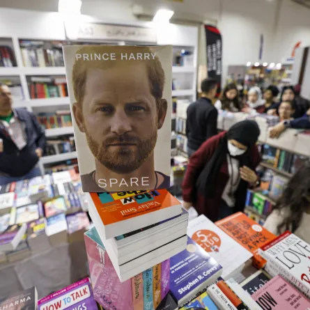 People browse books behind a copy of "Spare" by Britain's Prince Harry at a stall at the 54th Cairo International Book Fair in Egypt's capital on January 29, 2023. Khaled DESOUKI / AFP