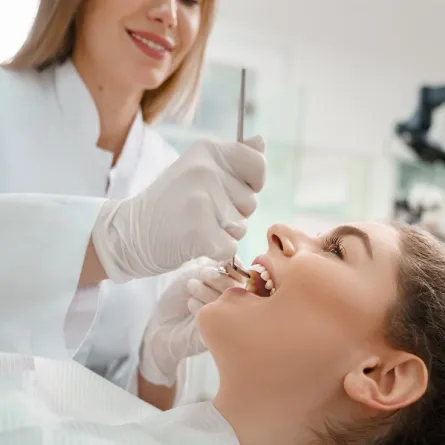 طبيبة تجري فحص للأسنان للتأكد من سلامة وصحة اللثة والأسنان (المصدر: Adobe.Stock)