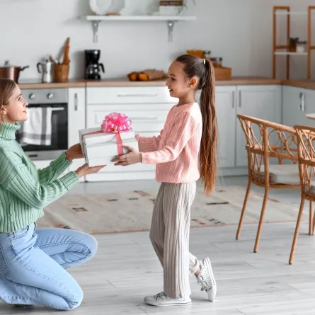 صورة لطفلة تقدم الهدية لأمها بمناسبة يوم المرأة العالمي