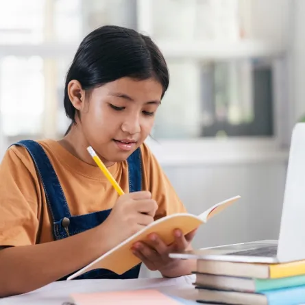 صورة لطفلة تسجل حروف العربية