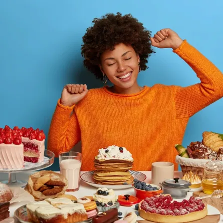 صورة لحامل تجلس أمام وجبات شهية