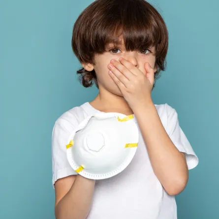 صورة لطفل يضع يده على فمه