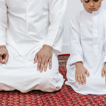 صورة لطفل يصلي بجانب والده