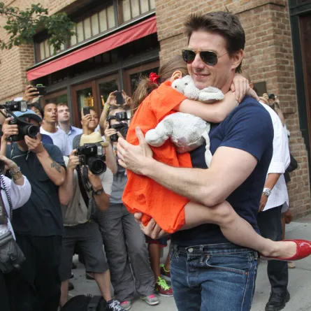 Tom Cruise leaves his hotel carrying daughter Suri for her gymnastics class on July 17, 2012 in New York, NY.  MEHDI TAAMALLAH / AFP