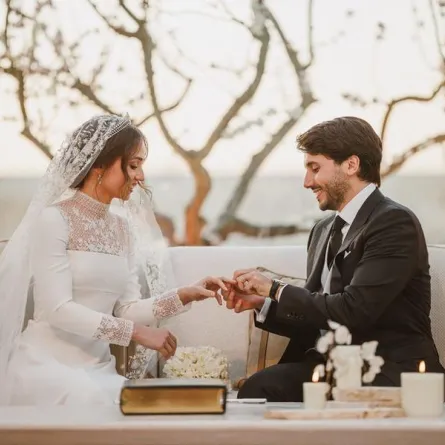  A handout picture released by Jordan's Royal Palace shows the groom, Jameel Alexander Thermiotis, putting the ring on the finger of his bride, Princess Iman -- the eldest daughter of the Jordanian monarch -- during their wedding ceremony in Amman on March 12, 2023. The daughter of King Abdullah II married Thermiotis, who was born in 1994 in Venezuela to a family of Greek origin, and currently works in the field of finance in New York. AFP PHOTO / JORDANIAN ROYAL PALACE