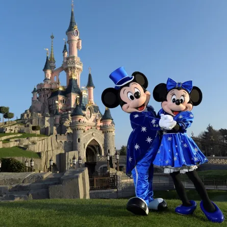 Disney characters Mickey and Mini mouse pose in front of the Sleeping Beauty Castle to mark the 25th anniversary of Disneyland - originally Euro Disney Resort - on March 16, 2017 in Marne-La-Vallee, east of the French capital Paris. BERTRAND GUAY / AFP