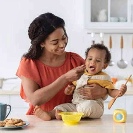 صورة لأم تقدم الطعام الصلب لرضيعها