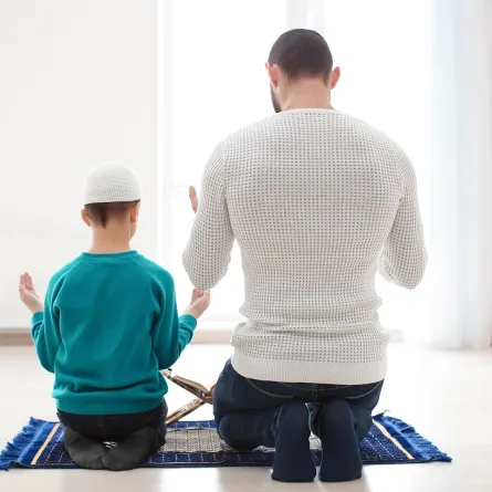 صورة لطفل يصلي مع والده