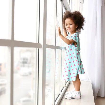 صورة لطفلة تتمشى بجانب الشباك