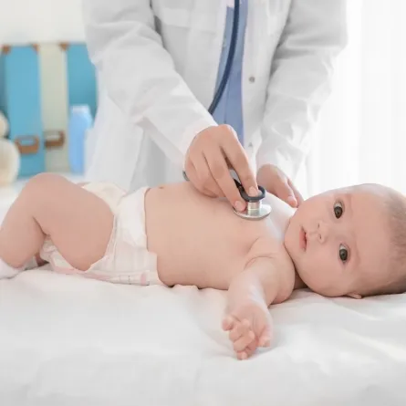 صورة لطبيب يفحص طفلاً رضيعاً