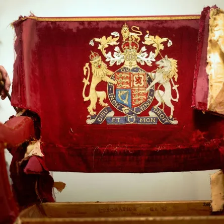 An upholsterer works on restoring a throne chair at the Marlborough House workshops in London, in the lead up to the coronation of Britain's King Charles III on February 17, 2023.Victoria Jones / POOL / AFP