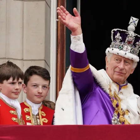 King Charles III waves from the Buckingham Palace balcony in central London on May 6, 2023, after his coronation. (Photo by Stefan Rousseau / POOL / AFP)