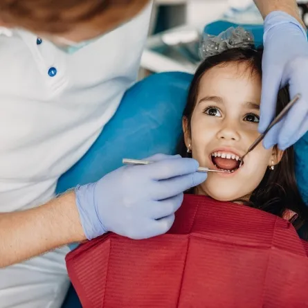 صورة لطبيب يفحص أسنان طفلة