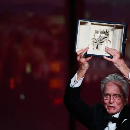 US actor Michael Douglas holds up the Honorary Palme d’or of he 76th Cannes Film Festival he received during the opening ceremony in Cannes, southern France, on May 16, 2023. (Photo by CHRISTOPHE SIMON / AFP)