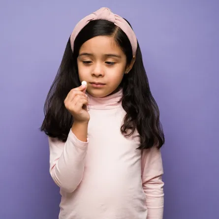 صورة لطفلة تحمل دواء