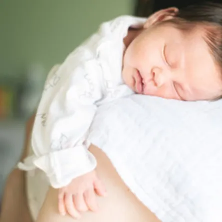 صورة لأم تكرع طفلها وهو نائم