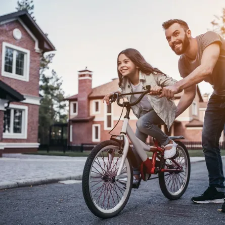 صورة لأب يعلم ابنته ركوب الدراجة