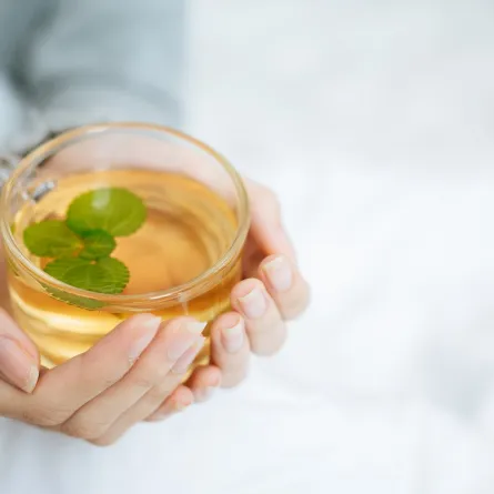 صورة لامرأة تحمل كوباً من الشاي الأخضر